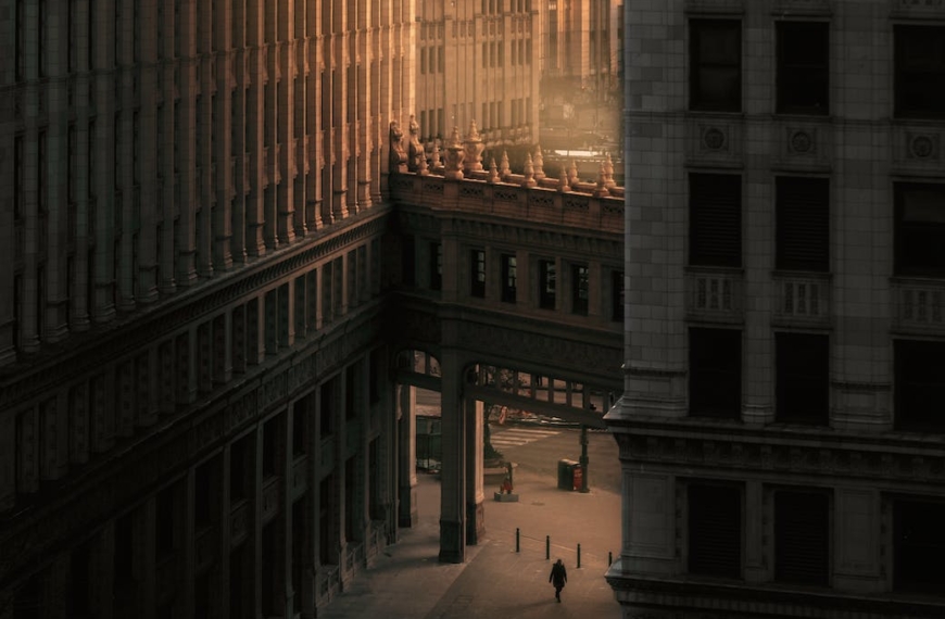person walking on street between buildings