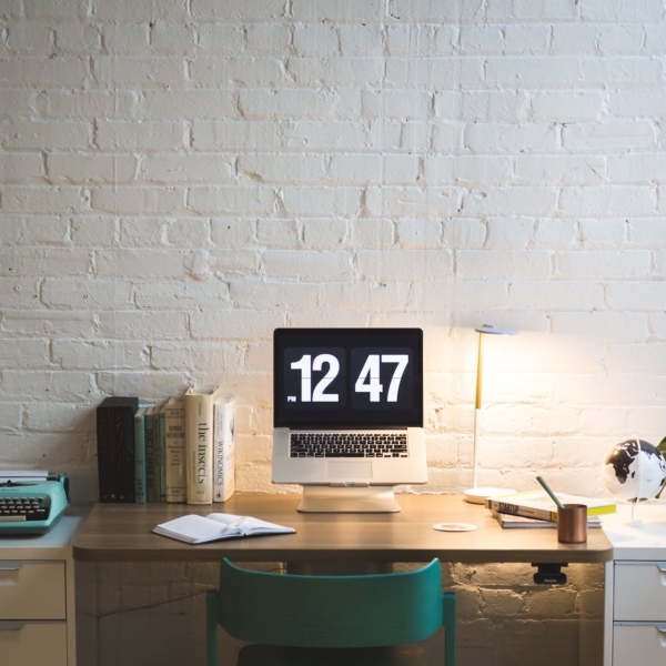 silver and black digital alarm clock on table