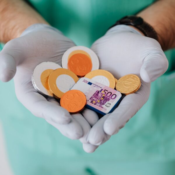 faceless doctor with chocolate coins in hands