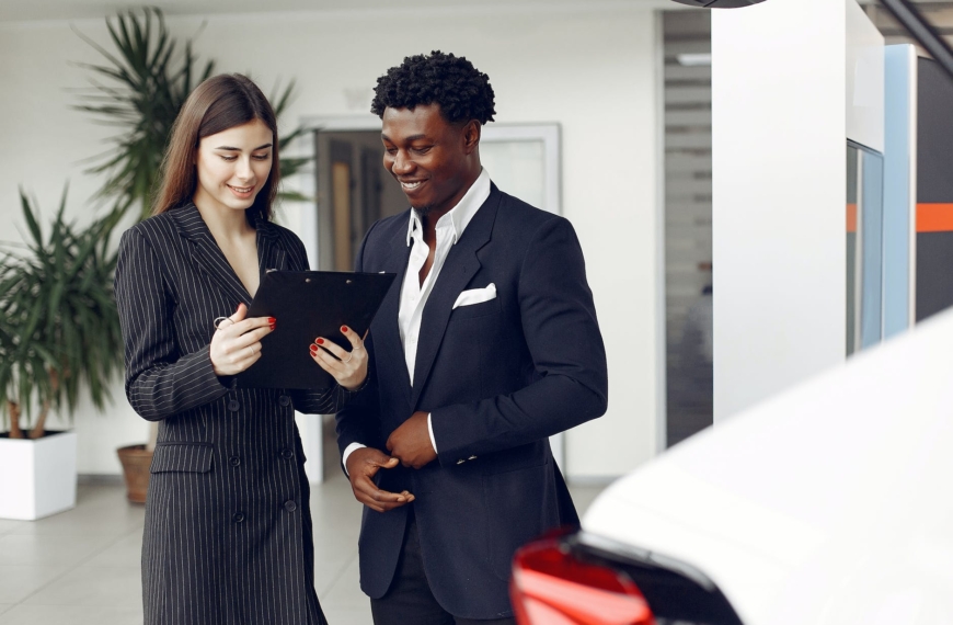 car dealer and client looking at a document