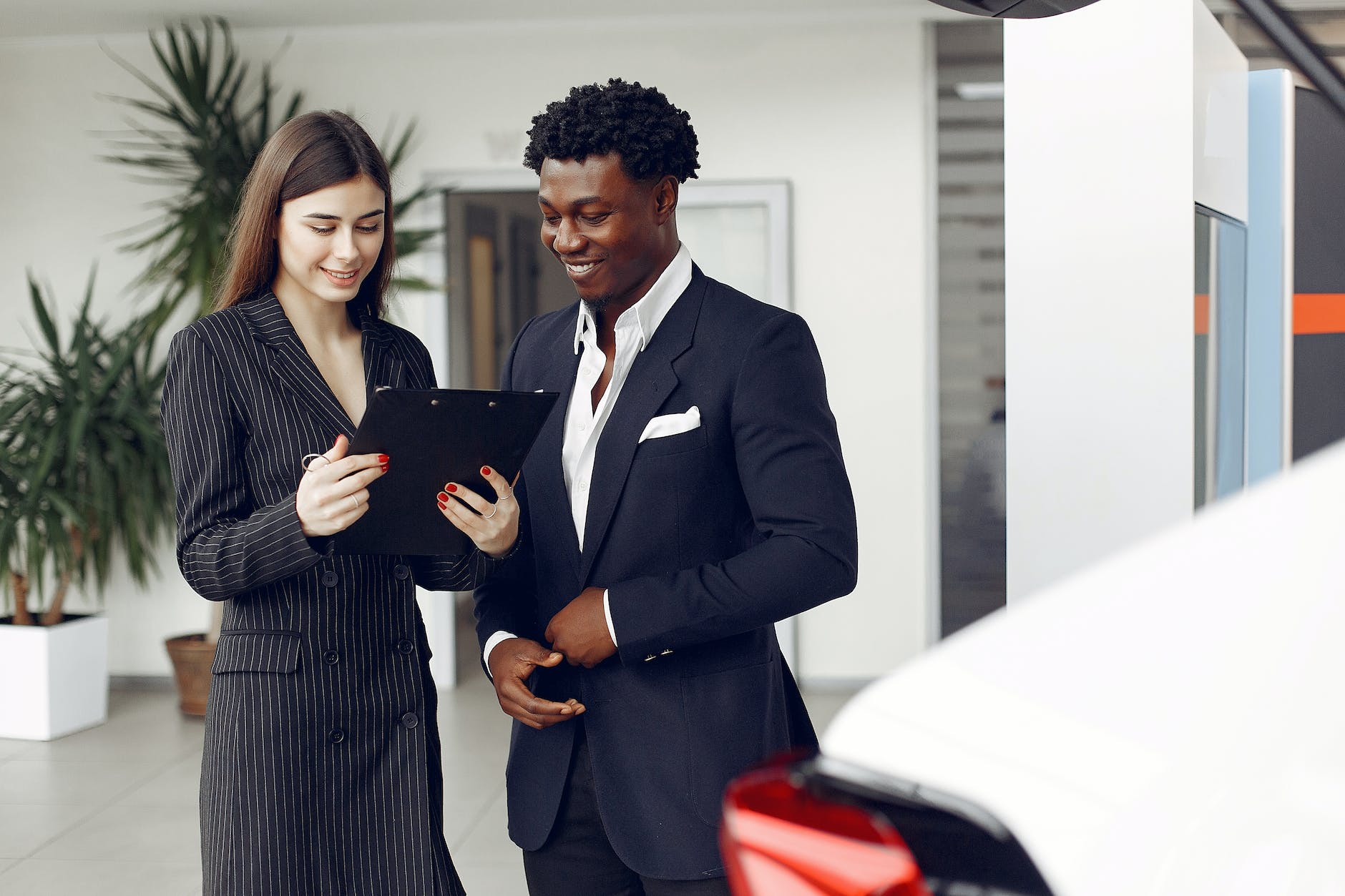 car dealer and client looking at a document