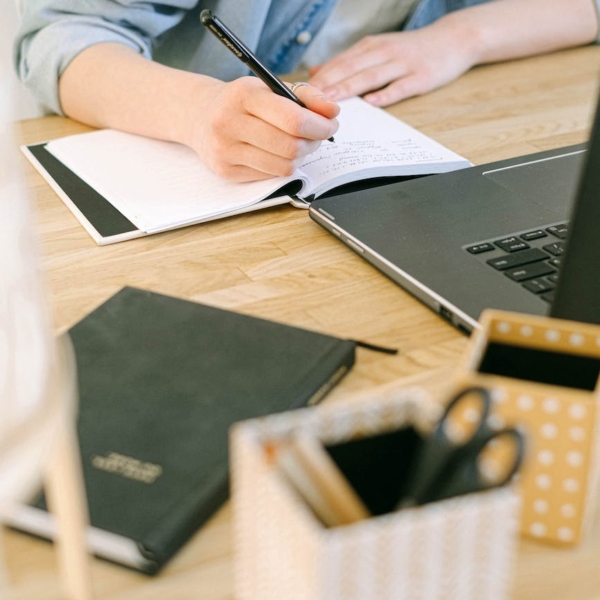 person writing on a notebook