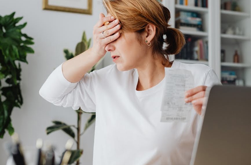 woman sitting in front of a laptop holding a receipt