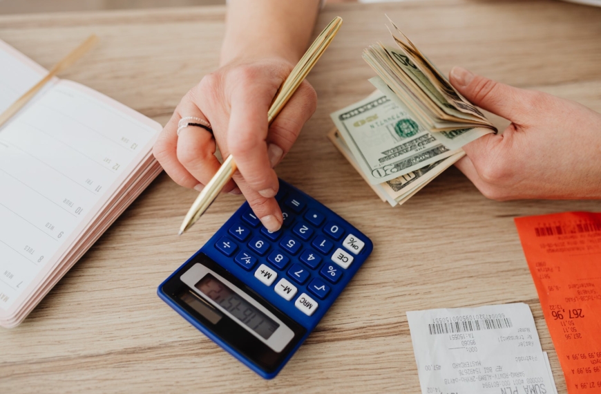 woman calculating money and receipts using a calculator