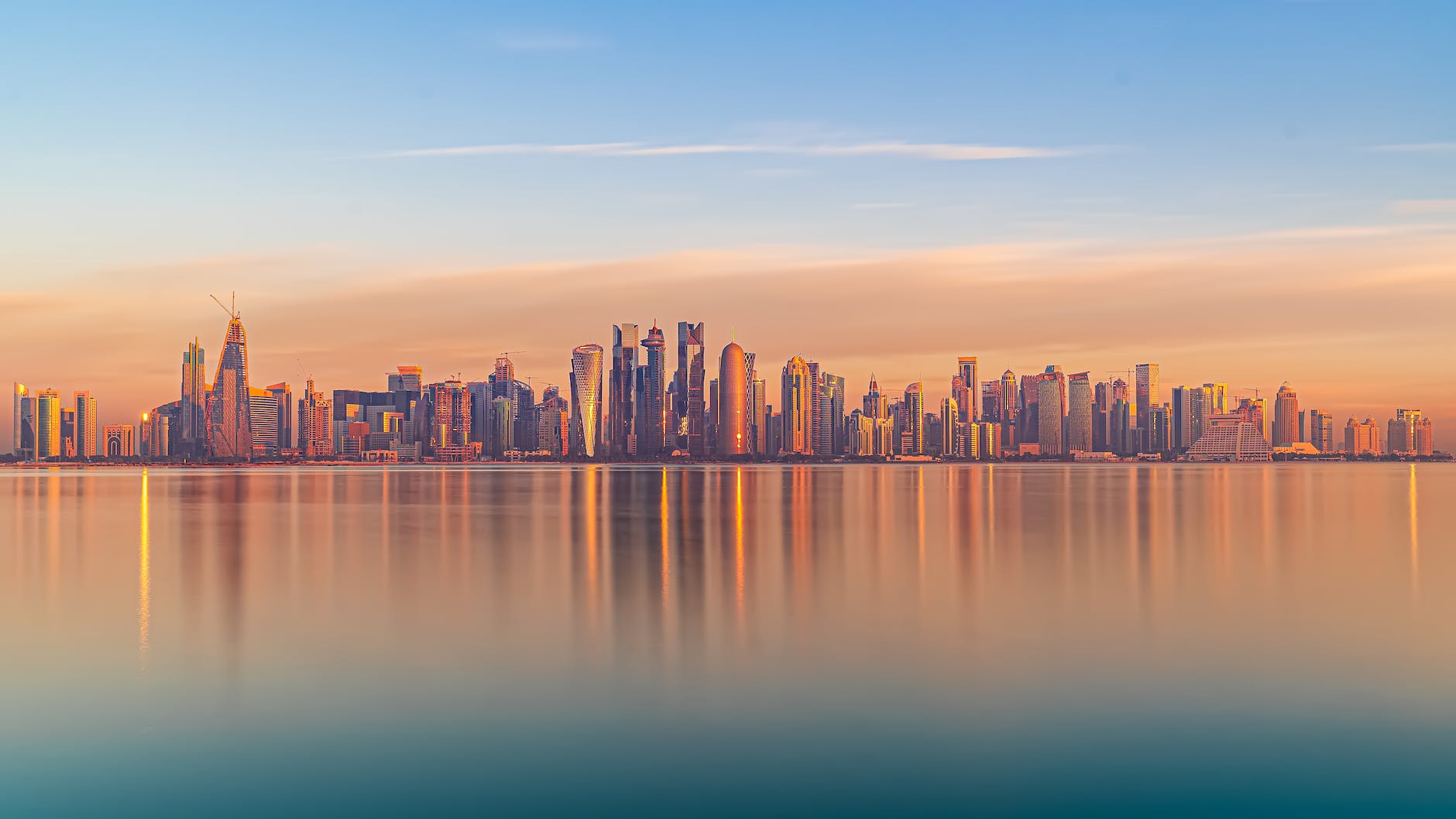 scenic cityscape of modern coastal megapolis under sunset sky