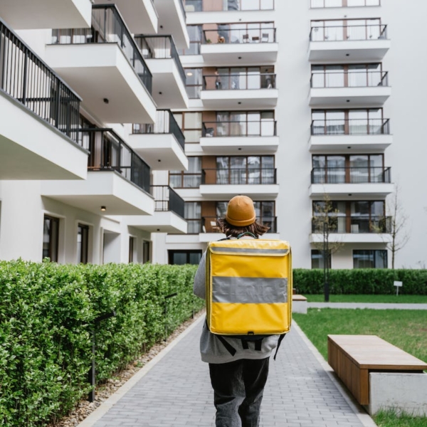 person carrying a bag walking on a sidewalk