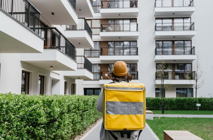 person carrying a bag walking on a sidewalk