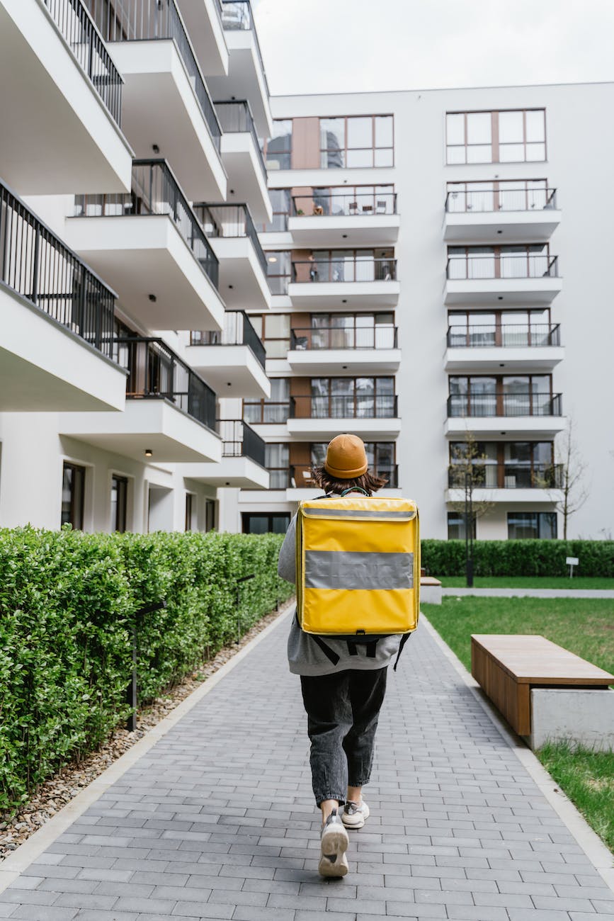 person carrying a bag walking on a sidewalk