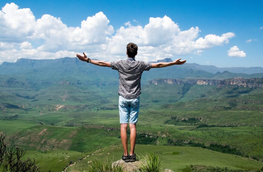man wearing grey shirt standing on elevated surface