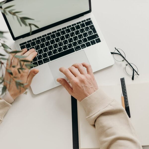 person in beige long sleeve shirt using macbook pro