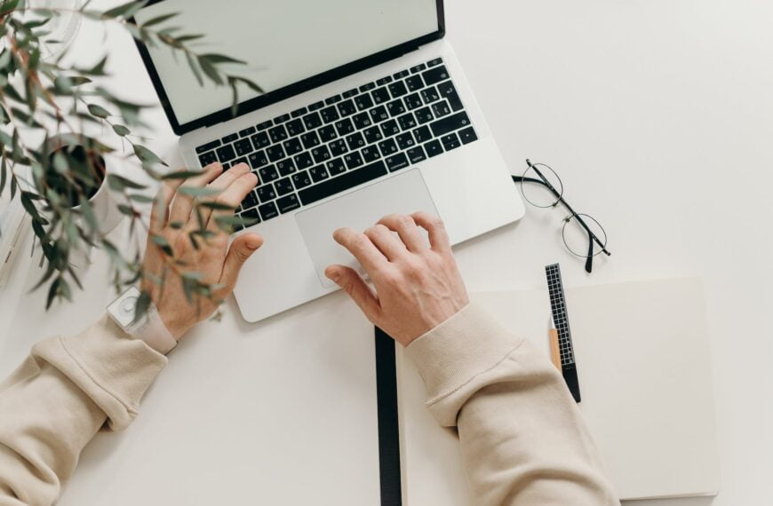 person in beige long sleeve shirt using macbook pro