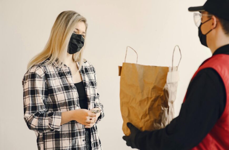 young female customer receiving grocery order during coronavirus pandemic