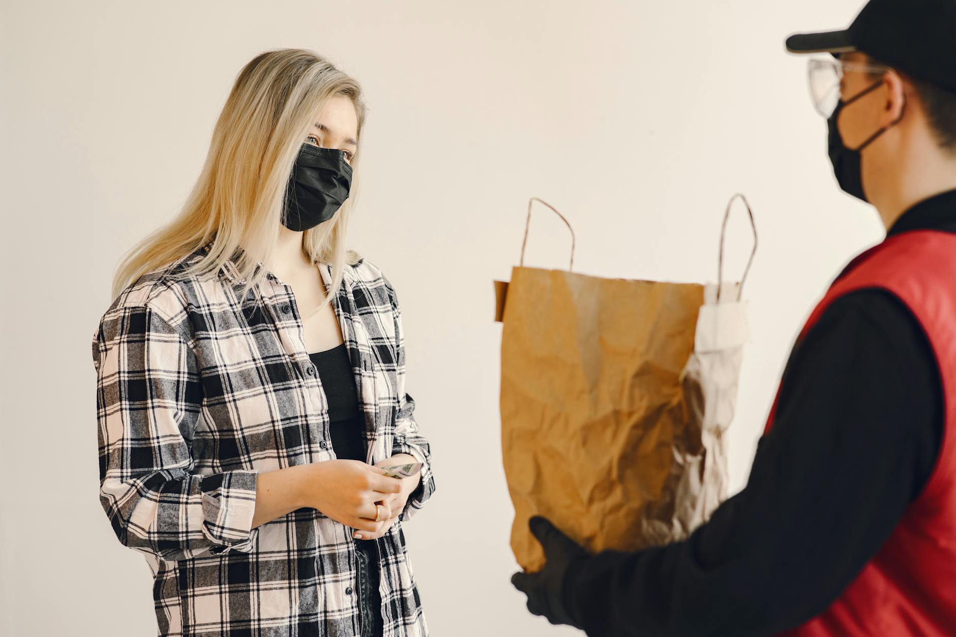 young female customer receiving grocery order during coronavirus pandemic