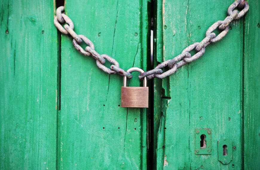 brass colored metal padlock with chain