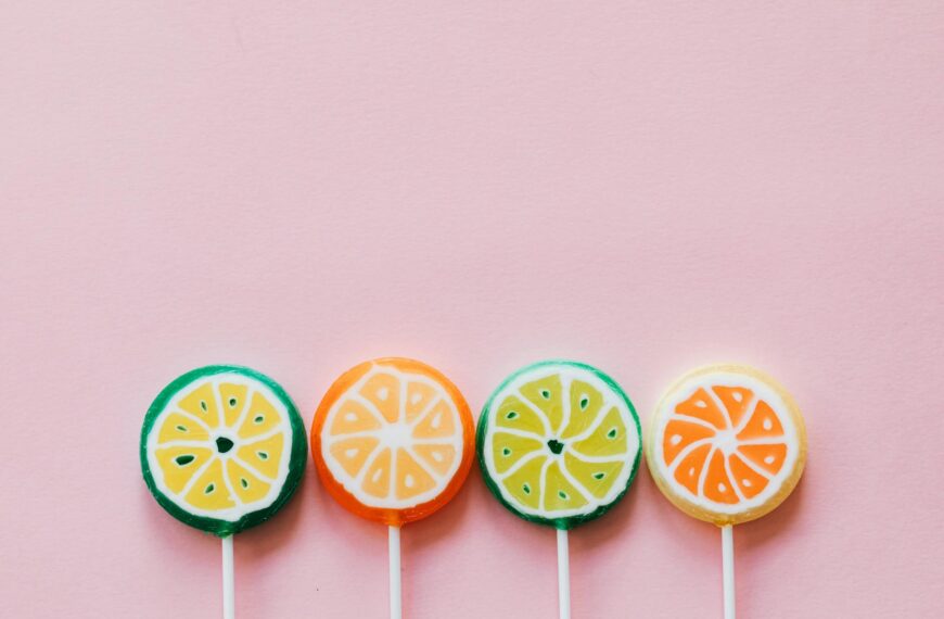 assorted colorful lollipops on pink background