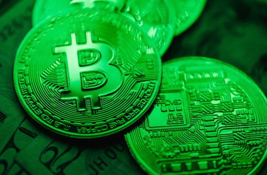 closeup of bit coins in a green light