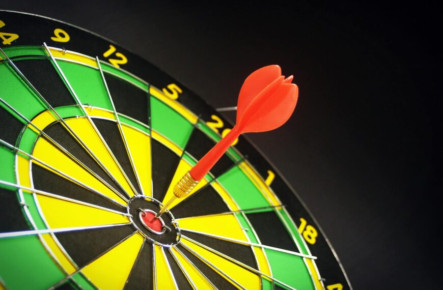 red and brass dart pin on dartboard