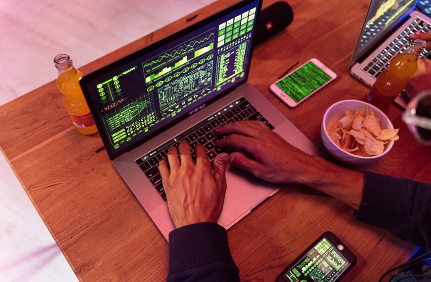 person using macbook pro on brown wooden table