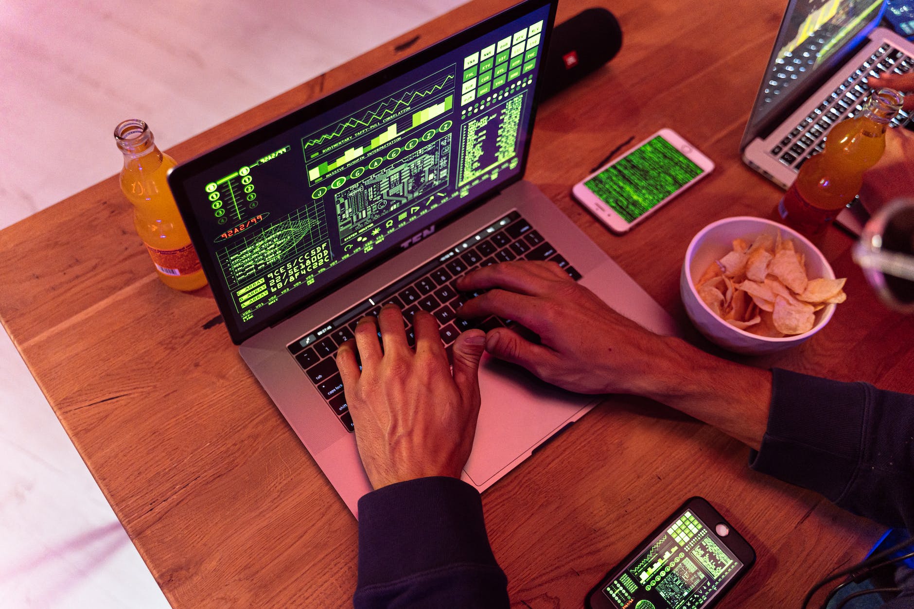 person using macbook pro on brown wooden table