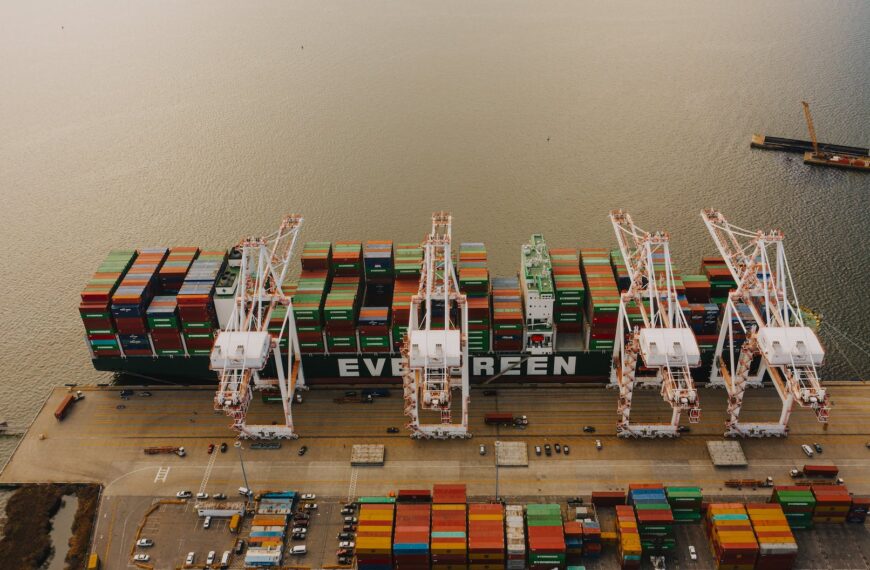 cargo ship near pier with lifting cranes