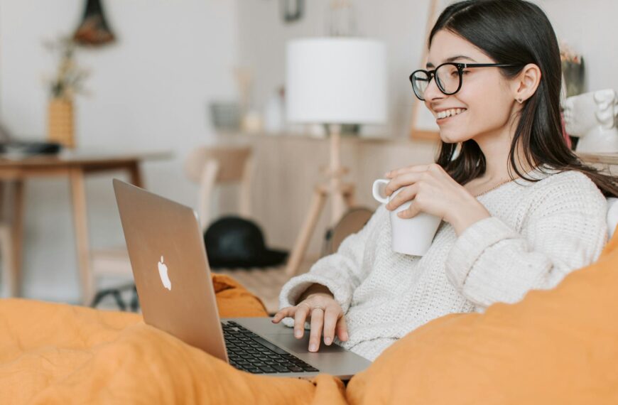 woman having coffee while using laptop