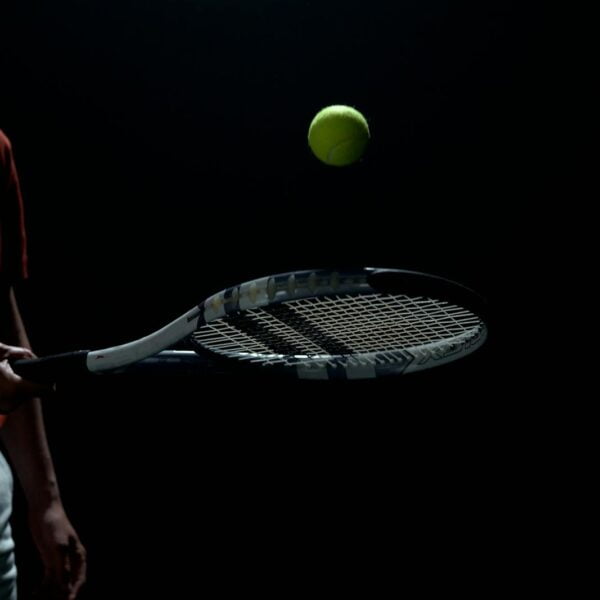 a player bouncing the tennis ball off his racket