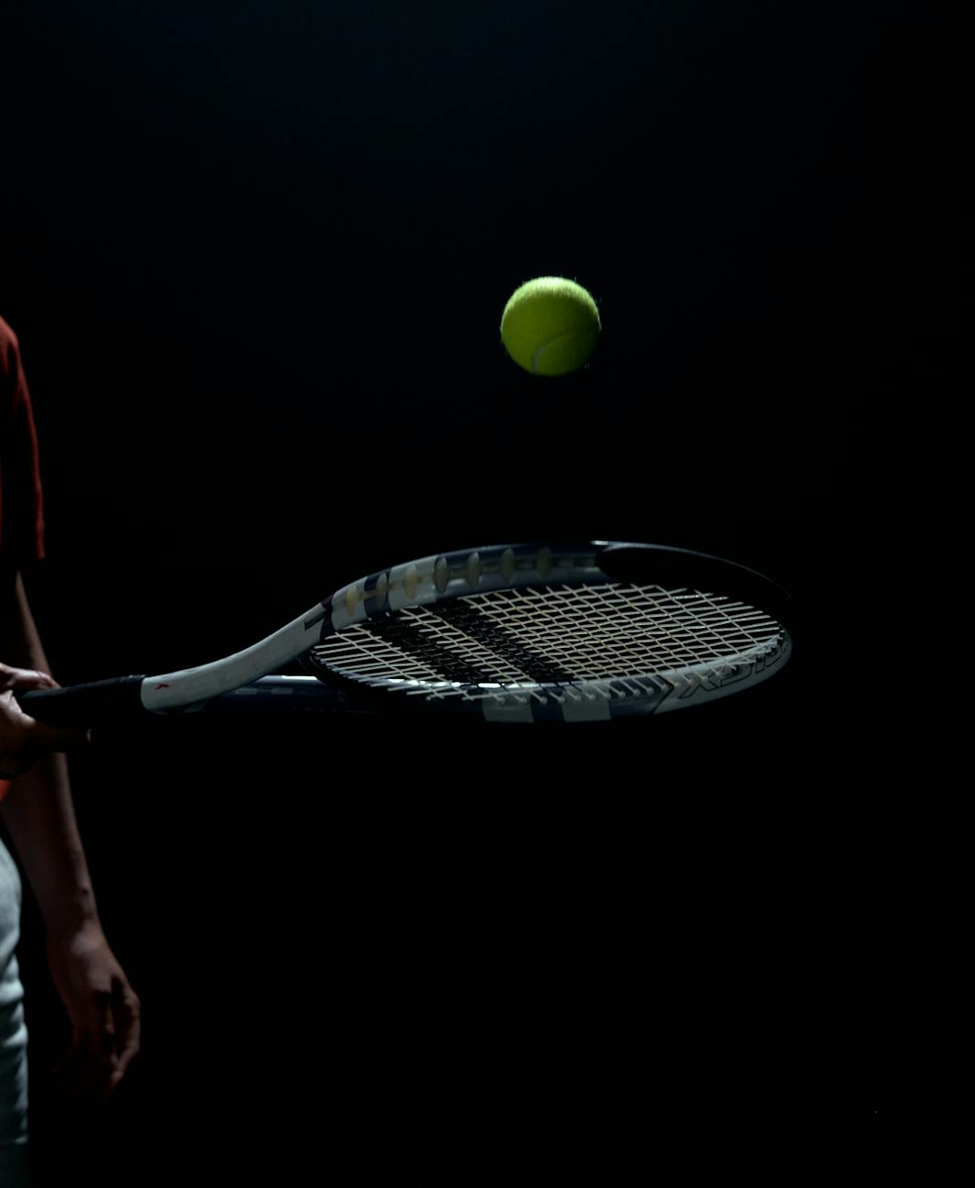 a player bouncing the tennis ball off his racket