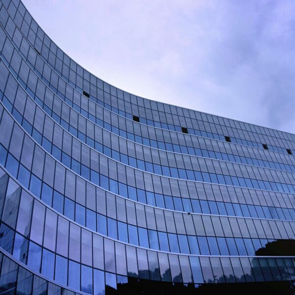 fish eye view photo of glass high story building over white cloudy sky during daytime
