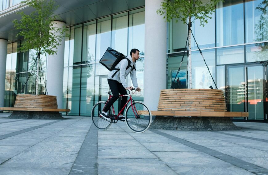 woman in white long sleeve shirt and blue denim jeans riding on black city bike during