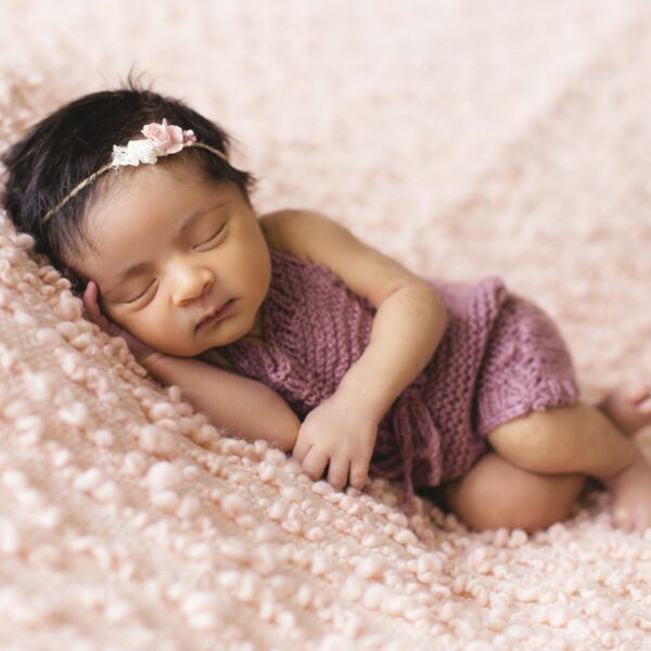 toddler lying on pink fleece pad