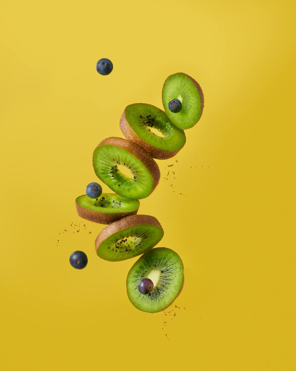 kiwi slices and blueberries in midair